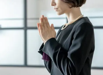 葬儀で手を合わせる女性